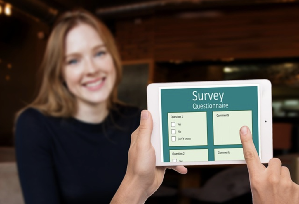 csat survey questionnaire on a tablet being held with an onlooking person smiling