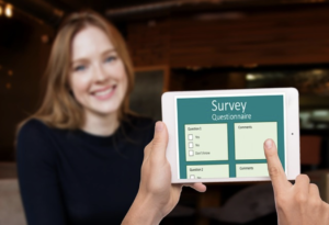csat survey questionnaire on a tablet being held with an onlooking person smiling