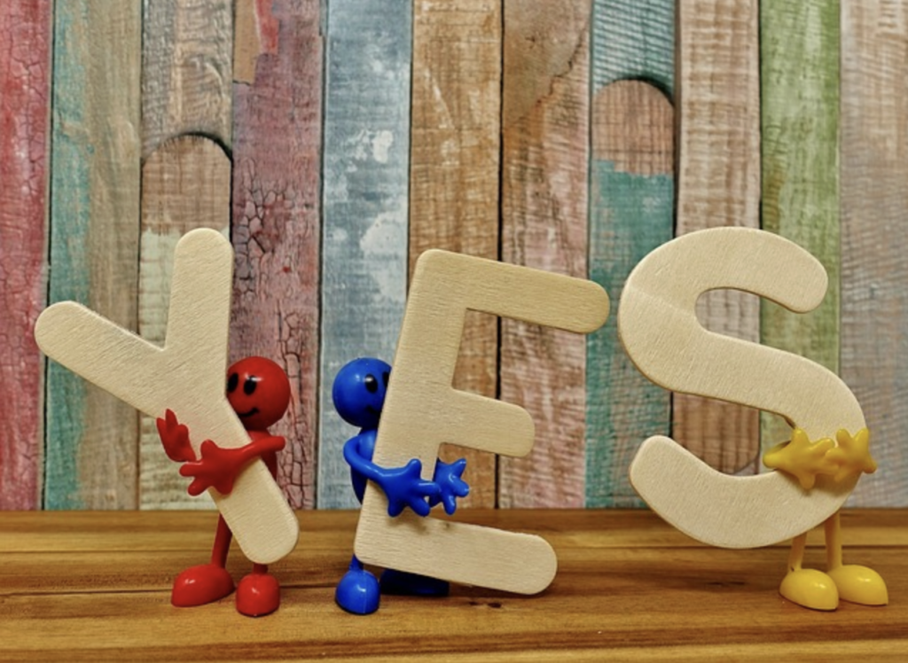 stick figurines holding the letters that spell yes